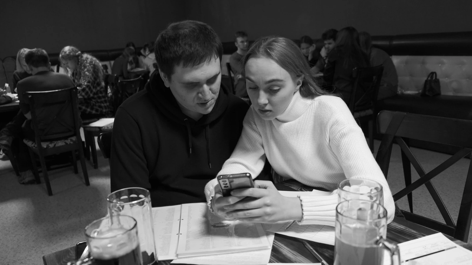 Двое участников обычной игры «Детектума» вместе изучают материалы дела